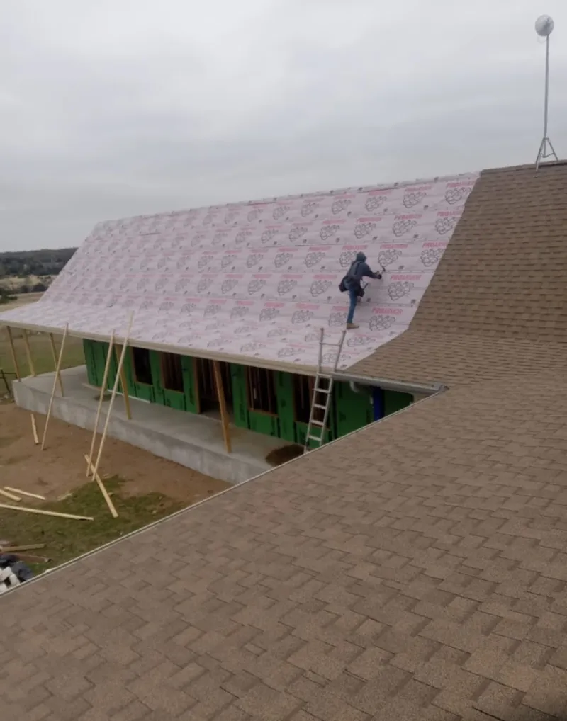 Worker preparing underlayment for a metal roof installation in Burr Ridge